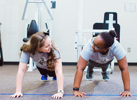 两个suncitygroup太阳集团的学生在健身房锻炼. 